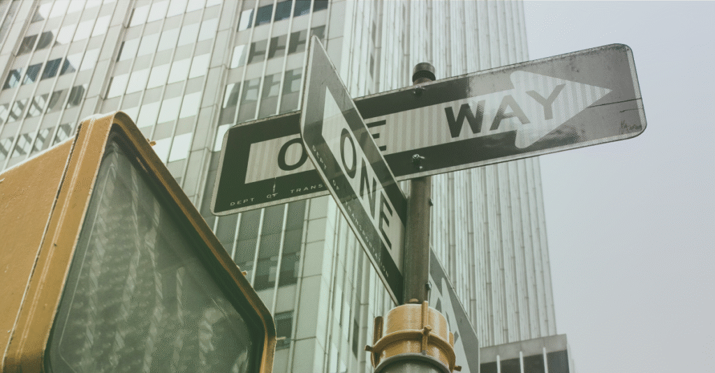 one way sign pointing in multiple direction, representing cross-border payment differentiators such as reach, visibility and reliability